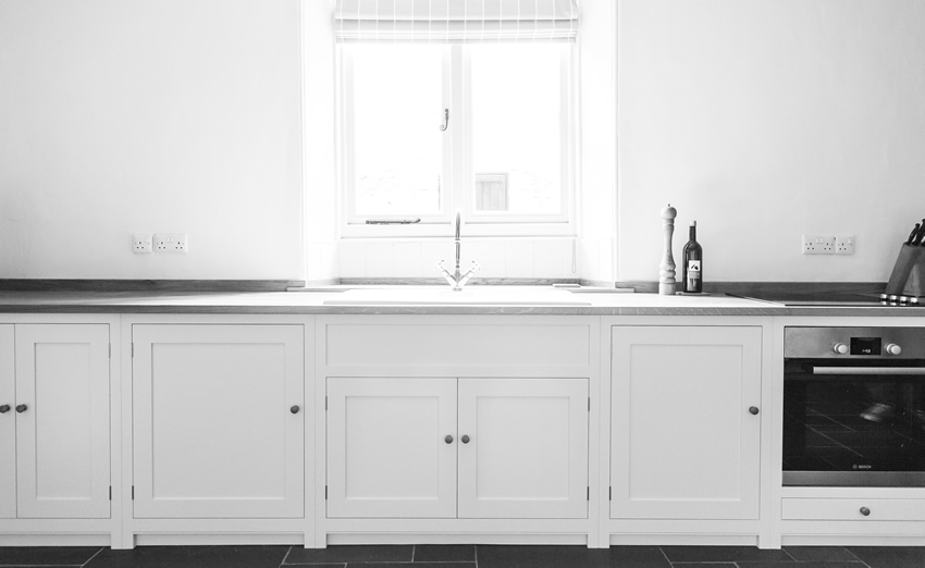 Shaker style kitchen. Birch plywood cabinets with hand painted hardwood frames (Farrow and Ball Estate Eggshell, Pale Powder).Traditional inset sink and integral dishwasher. Inset cooker hob and integral oven. 4.5m full stave oak worktop with upstand. Solid brass hinges and adjustable brass shelf supports. Solid oak dovetailed drawers with painted hardwood fronts. Hand turned beech knobs.