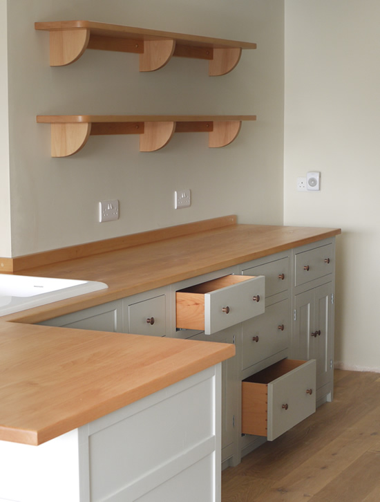 Shaker style kitchen. Birch plywood cabinets with hand painted hardwood frames (Farrow and Ball, Lamp Room Gray). Sink area with integral dishwasher, traditional ceramic inset sink and full stave beech top and upstand. Dovetailed drawers made of solid beech with painted hardwood fronts and walnut hand turned knobs.