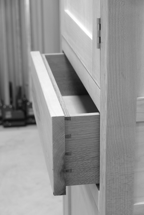 Small larder cupboard before painting. Solid maple carcass construction with birch ply panels and shelves. Oak dovetailed drawers and oak cornice.