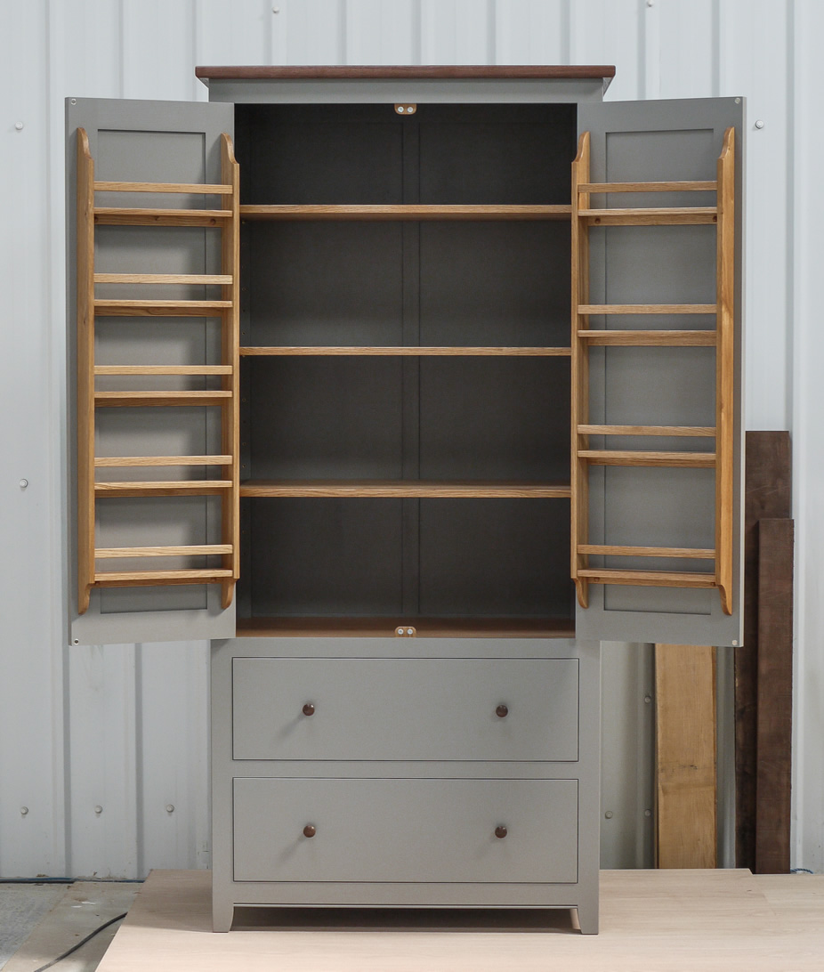 Larder cupboard handpainted in Farrow & Ball Estate Egshell - 'Mole's Breath'. Tulip wood carcass with birch ply panels and shelves. Dovetailed oak drawers on high quality soft close runners. Oak spice racks. Solid brass hinges and adjustable brass shelf supports. Solid walnut cornice and knobs.