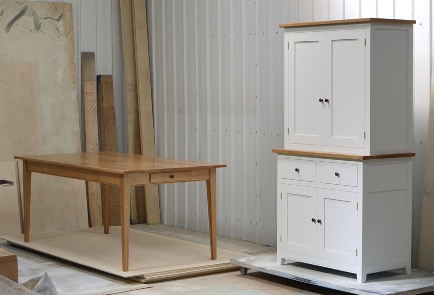 Two part dresser/larder handpainted in Farrow and Ball Estate Eggshell - 'Cabbage White'. Tulip wood carcass with birch ply panels and shelves. Oak dovetailed drawers and oak cornice. Hand-turned walnut knobs and pulls. Oak Shaker style table with tapered legs and oak dovetailed drawer. 