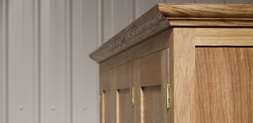 Oak wardrobe with solid oak carcass and panels. Oak faced birch ply shelves. Dovetailed oak drawers on high quality soft close runners. Bespoke cornice in solid oak and hand turned oak knobs. Solid brass hinges and adjustable shelf supports.